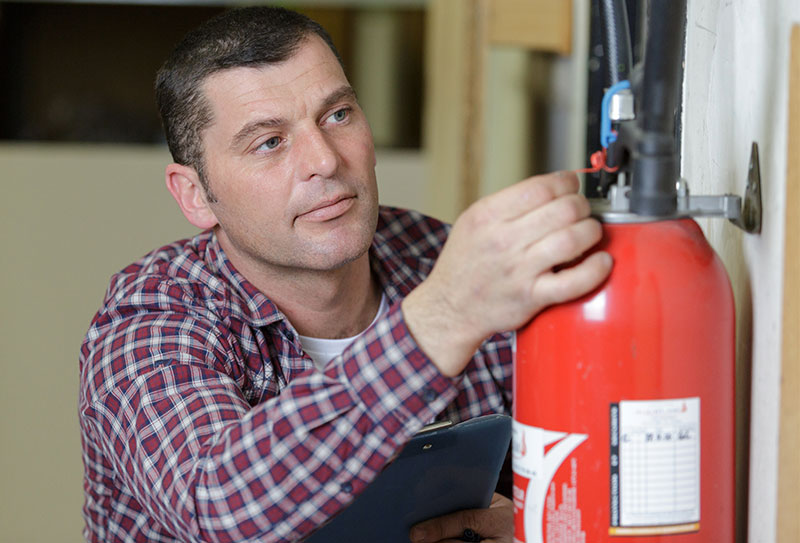 Man examining a fire extinguisher